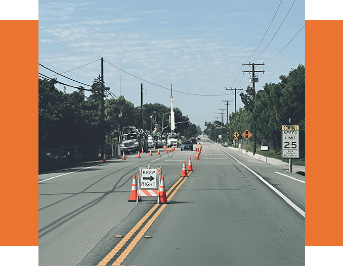 A road with orange cones blocking off the street.